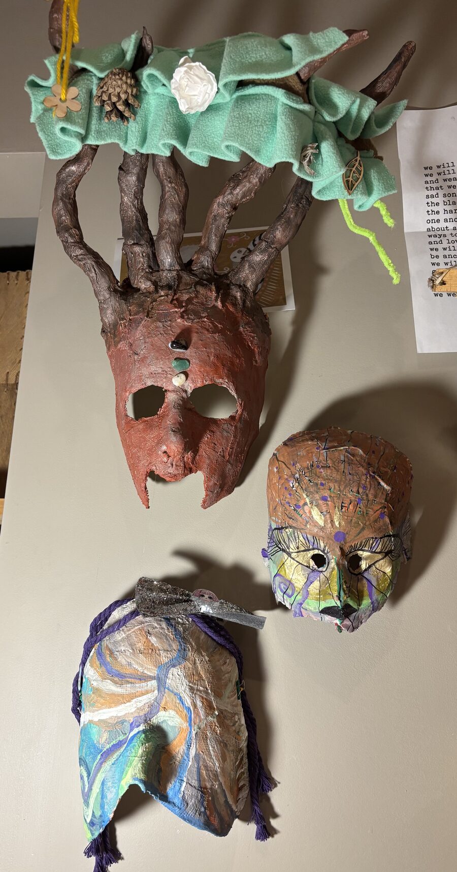 Handcrafted papier-mâché masks with natural and textile elements by Pamela Vialoux